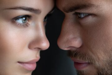 Two individuals lean close together, gazing into each other's eyes, creating a moment of connection.